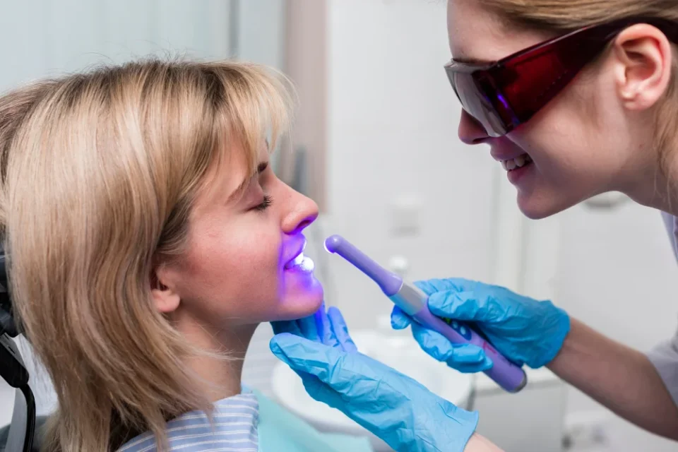 Dentist performing laser cold sore treatment on patient’s lip
